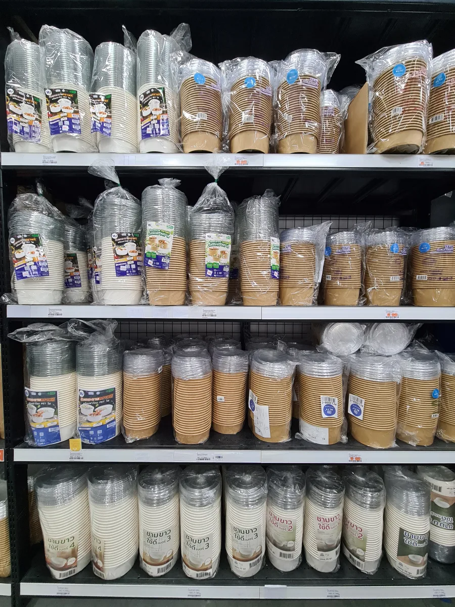 Paper bowls in several sizes with clear lids on the packaging shelves