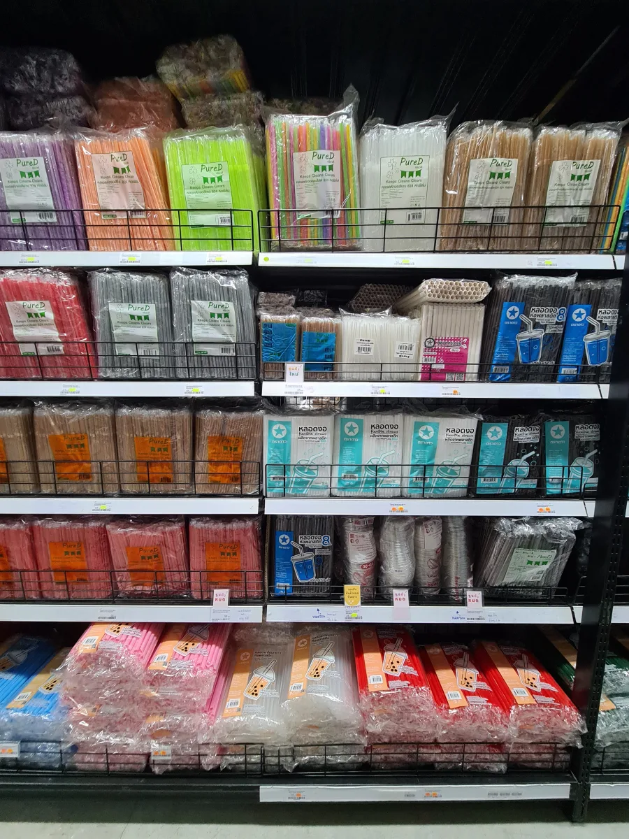 Colorful, white, paper, and plastic drinking straws on a store shelf